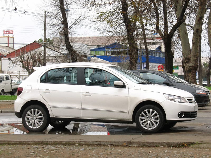 Volkswagen Gol branco de quatro portas, visto de lado, com frente curta e baixa e rodas de liga leve