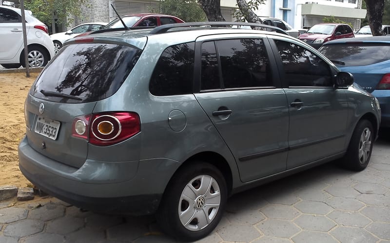 Volkswagen SpaceFox verde-acinzentado visto de trás e de lado, estacionado sobre piso de blocos, com lanternas traseiras de desenho arredondado, barras no teto e placa brasileira
